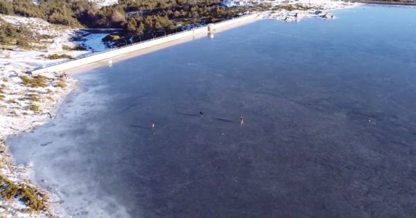 Pessoas caminham em lagoa congelada na Serra da Estrela